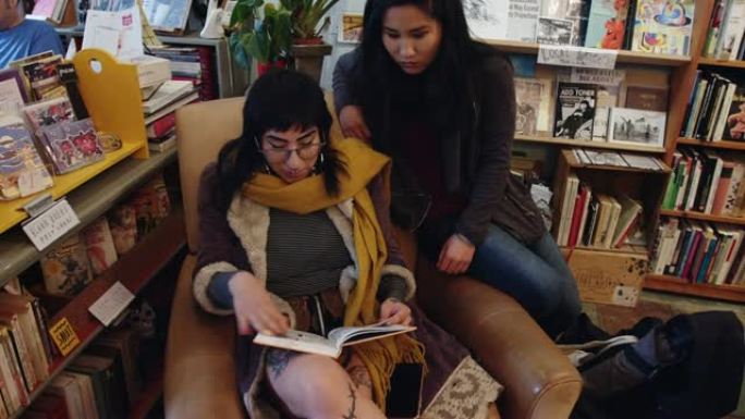 在书店里越过朋友的肩膀看书的女人