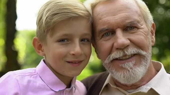 男孩和老人摆姿势，微笑着，与祖父建立信任关系