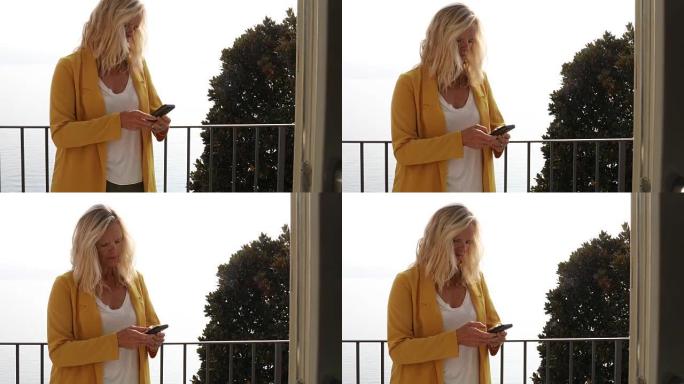 女人带着智能手机走上阳台
