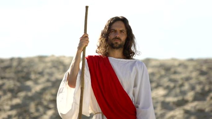 耶稣带着木制的杖站在沙漠中，宣扬基督教信仰的转变