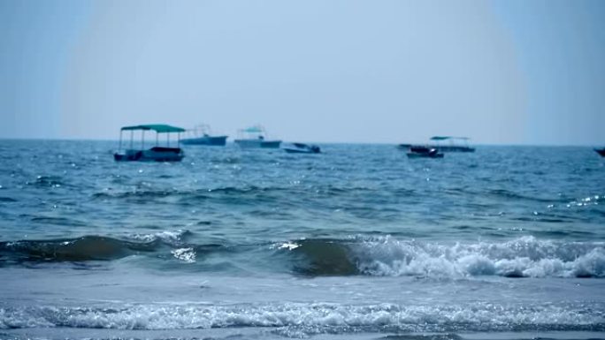 许多船在远处，海浪滚滚到海滩，印度果阿