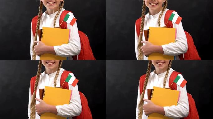 女学生拿着带有意大利国旗的复印书，对着镜头微笑，语言