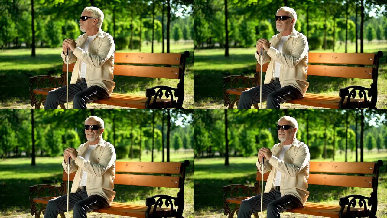 盲人坐在长椅上，听着公园里的声音，提高了感官