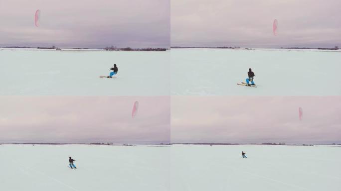 在冬季用滑雪板或滑雪板进行风筝冲浪。在风中在冰上溜冰。美丽的彩色的帆