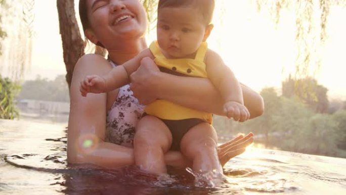 4k慢动作婴儿在游泳池里和父母一起玩。