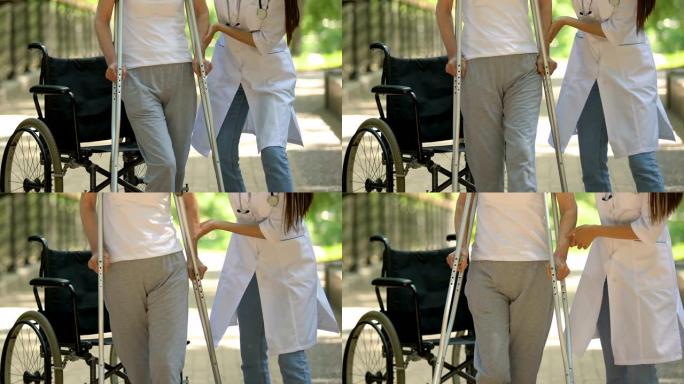 物理治疗师帮助坐在轮椅上的病人拄着拐杖走路