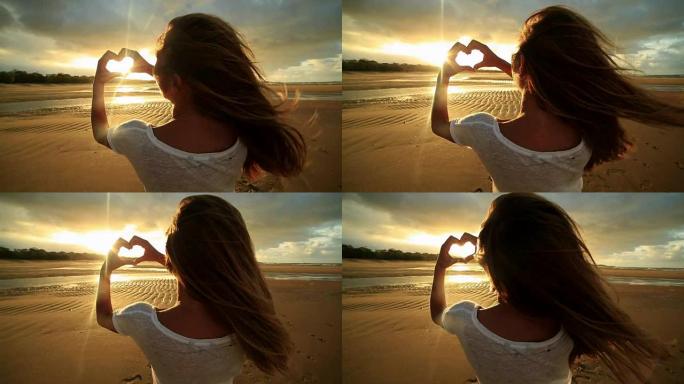 海滩上的高加索女性制作心形手指框