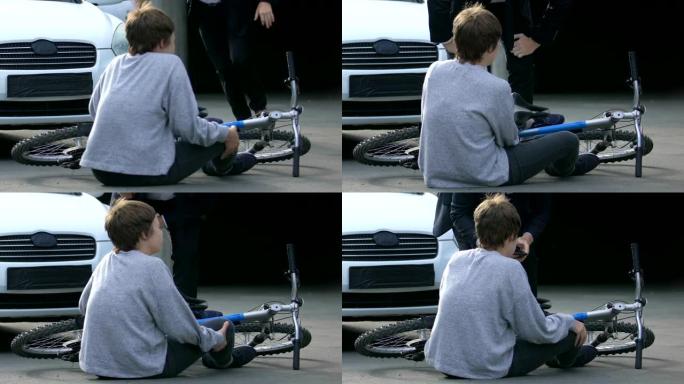 受伤的少年坐在自行车附近的路上，感觉被汽车撞伤，事故