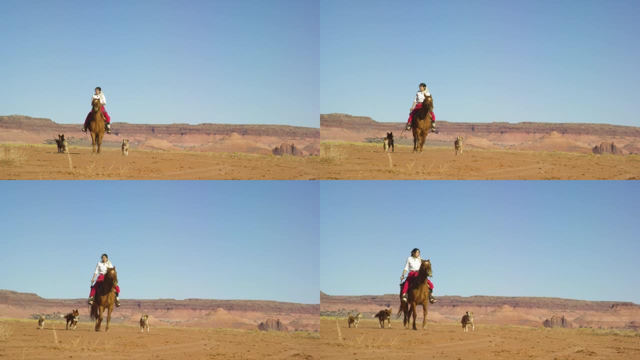 在晴朗明亮的日子里，一个穿着传统纳瓦霍族服装的十几岁的美国原住民女孩骑着她的马穿过纪念碑谷沙漠，带着