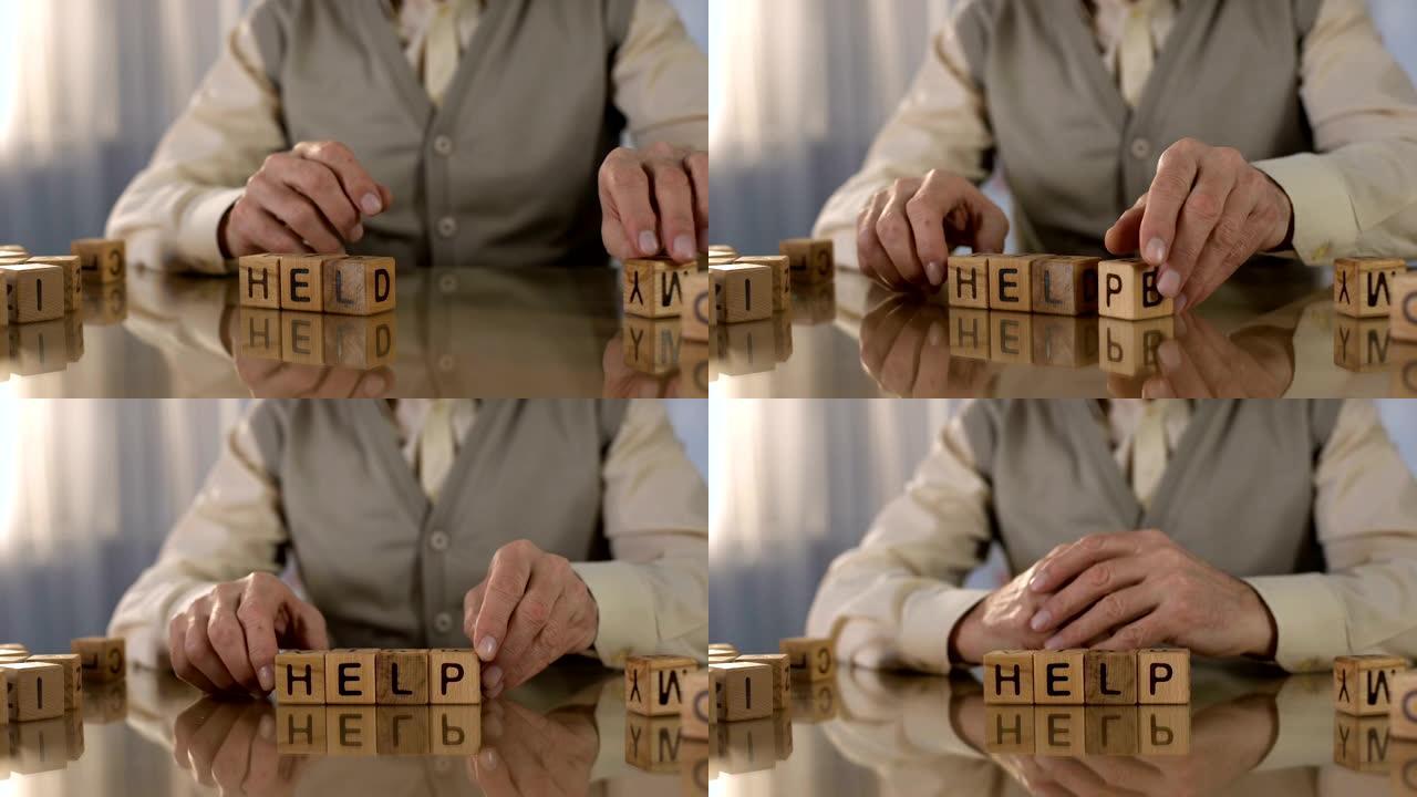 高级男子在桌子上制作木制立方体的单词帮助，帕金森氏病，震颤