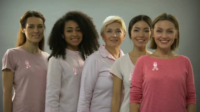 穿着粉色衣服、系着粉色丝带、面带微笑的女性是乳腺癌意识的标志