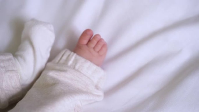 细心的妈妈双手穿着柔软的棉袜在婴儿的小脚上，新生儿护理