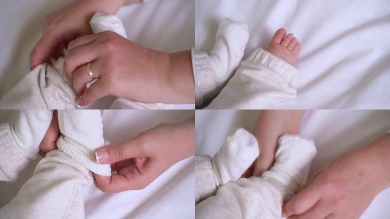 细心的妈妈双手穿着柔软的棉袜在婴儿的小脚上，新生儿护理