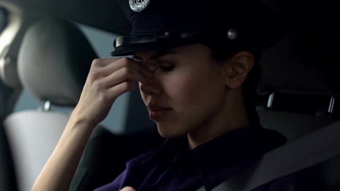 亚洲女警官擦鼻梁和摘掉帽子后，辛苦的一天