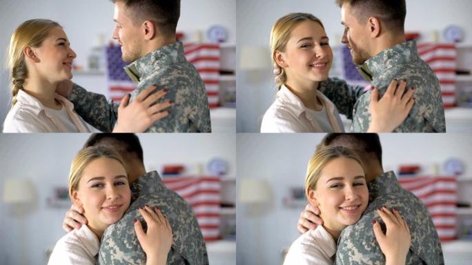 快乐的妻子拥抱着军人丈夫，对着镜头微笑，从战争中归来