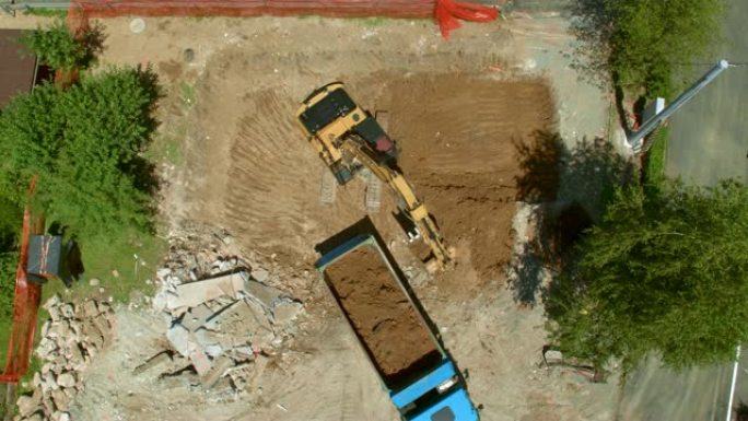 在挖掘机上进行空中关闭，将挖出的土壤装载到建筑工地的卡车上