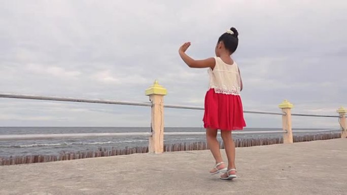 慢动作亚洲女孩在海边跳舞。