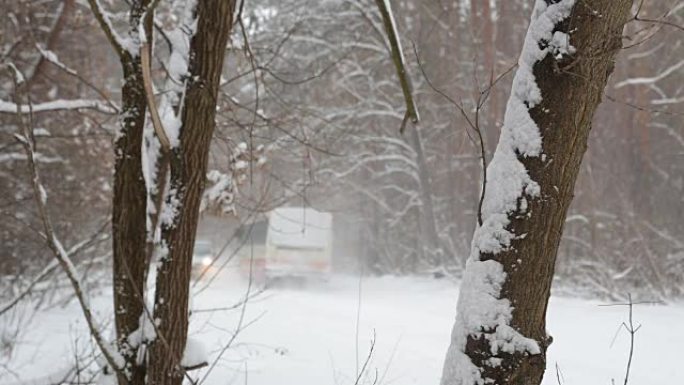 暴风雪中冰雪覆盖的道路上的汽车和公共汽车。