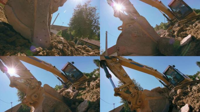挖掘机铲斗在阳光下挖成一堆杂物