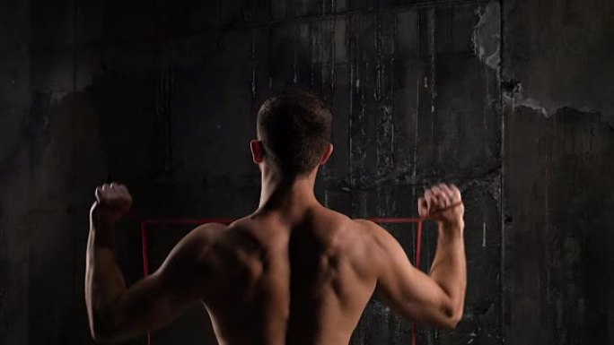健身男模在健身房用拉筋运动的后视图