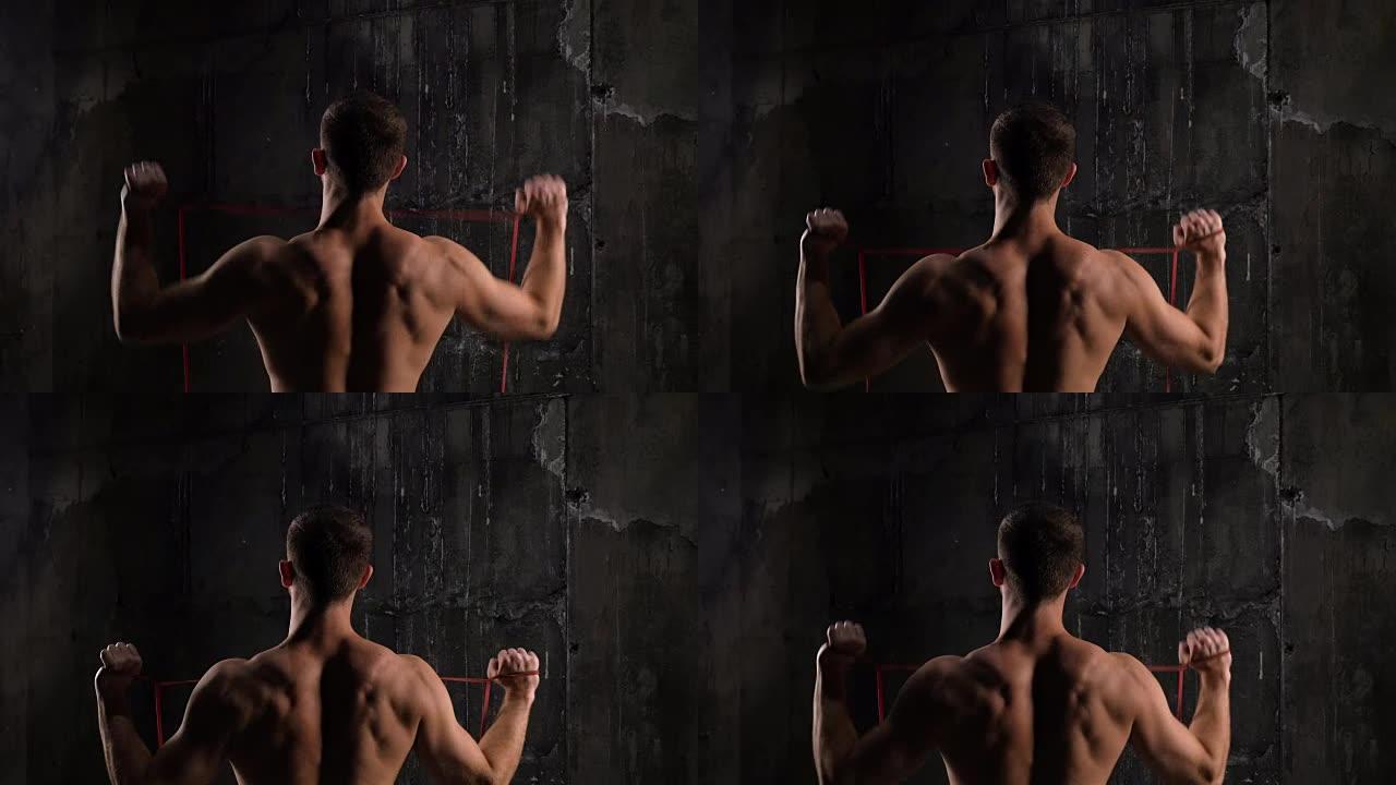 健身男模在健身房用拉筋运动的后视图