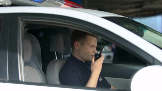 警察在车里使用对讲机，调度员通知紧急情况