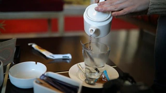Pouring tea into a tea cup