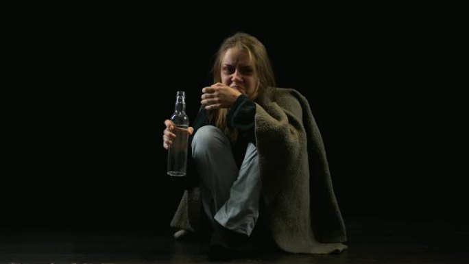 孤独的嗜酒女人从瓶子里喝伏特加，带着仇恨看着