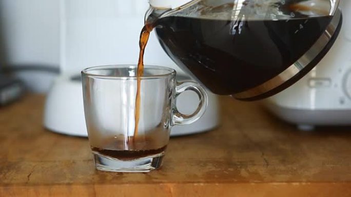 早上在家从玻璃壶里倒一杯热咖啡。