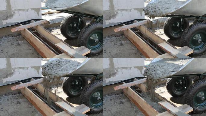 混凝土正在从独轮车中倒入木制模板。