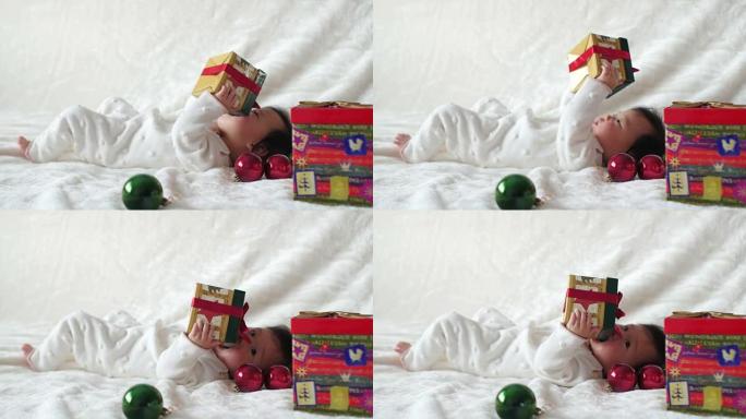 亚洲女婴玩圣诞小摆设和礼品盒