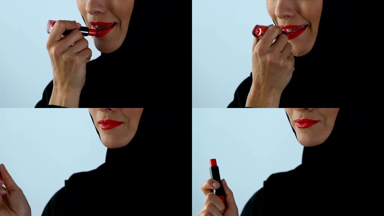戴头巾的阿拉伯女性化妆，涂红色唇膏，美容概念