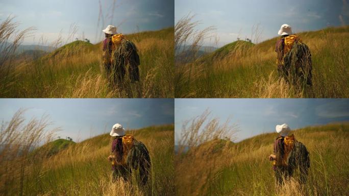 女人徒步旅行者站在草地上看着风景