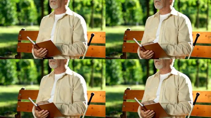 盲人坐在公园的长凳上阅读盲文中的书，社会适应