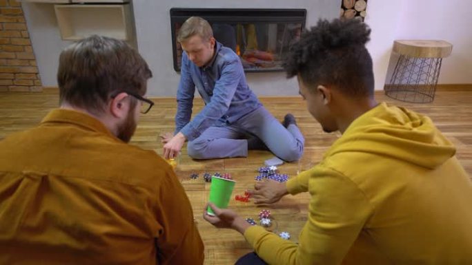 非洲裔美国人掷骰子，扑克筹码在地板上，朋友玩得开心