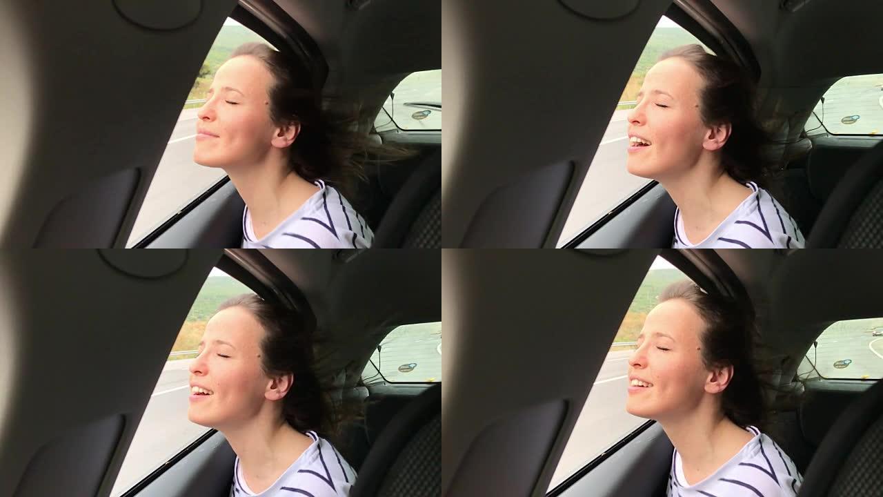 幸福-年轻的女人在汽车上，手在空中玩耍