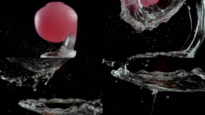 SLO MO LD在黑色背景下弹出粉红色的充水气球