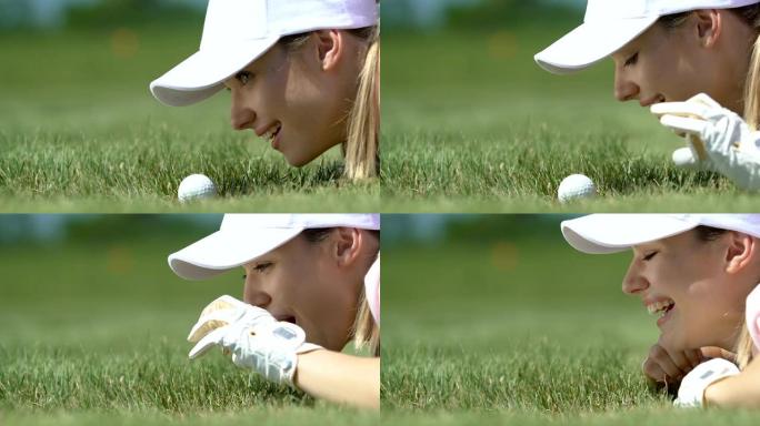 恶作剧女孩用手指将高尔夫球打入洞，玩得开心，特写