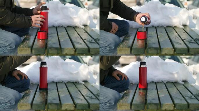Man pours tea from a thermos winter