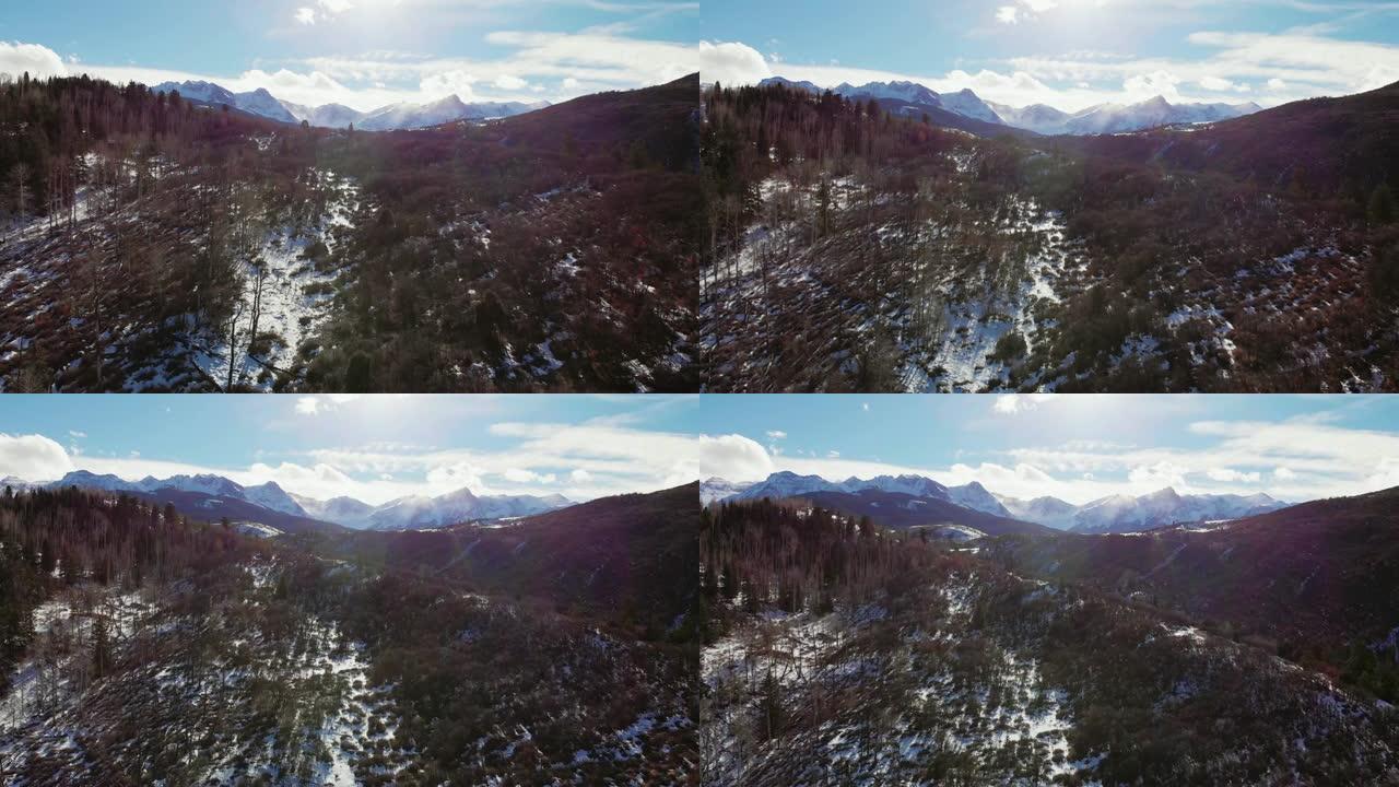 在一个明亮的冬日，卡车前进的空中无人机拍摄了科罗拉多州特柳赖德郊外圣胡安山脉 (落基山脉) 的森林和