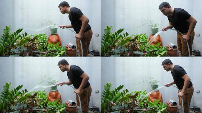 4k剪辑镜头，年轻人正在后院浇灌植物