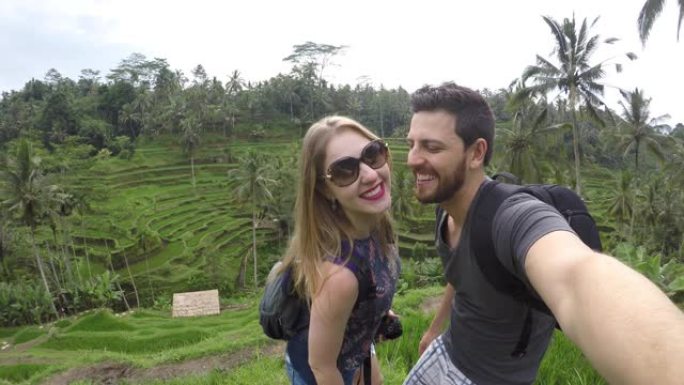 一对夫妇在印度尼西亚巴厘岛的米绿田里拍照