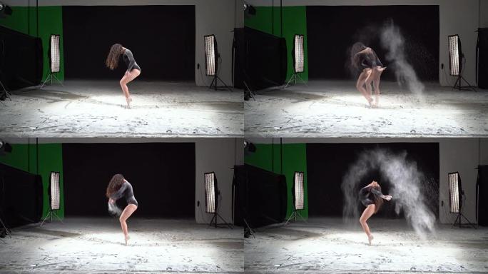 美丽的芭蕾舞演员在工作室里用粉雪在旋转木马里跳舞。慢动作