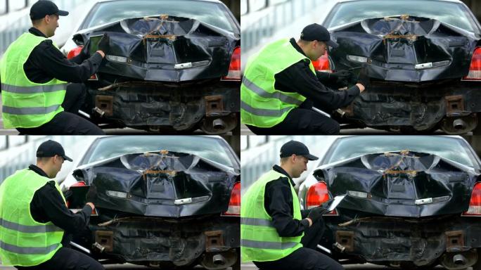 保险公司工作人员使用平板电脑拍摄汽车损坏的照片，发生事故
