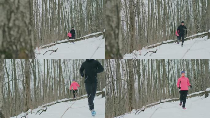 在阳光明媚的冬日早晨，积极美丽的年轻健康夫妇穿着运动服穿过森林。跳过树，克服路径的困难。越过障碍物