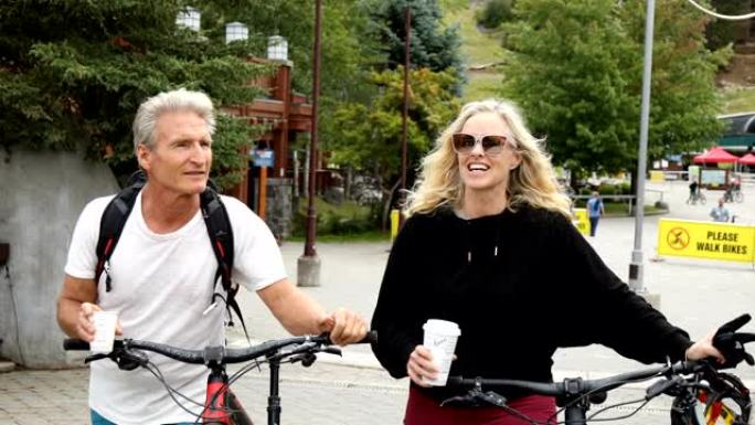 骑自行车的夫妇在骑自行车后在山村环境中放松
