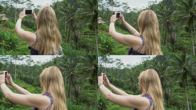 年轻的旅游女子在印度尼西亚巴厘岛的稻米区拍照