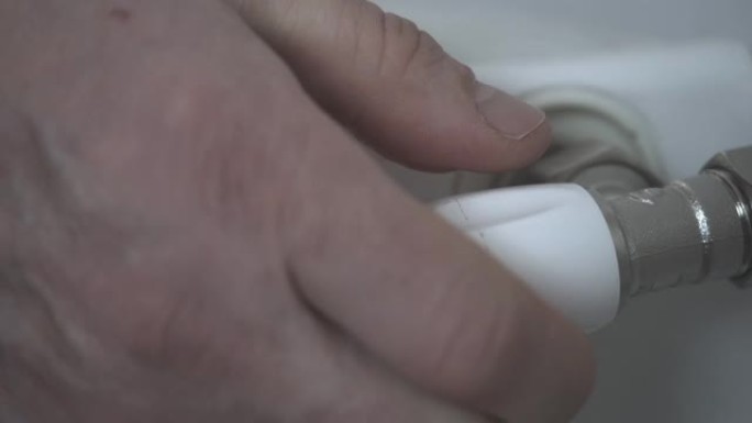 男性高加索人手转动水龙头的极端特写。无法识别的成年男子在浴室里打开水。生活方式，卫生，洗手。