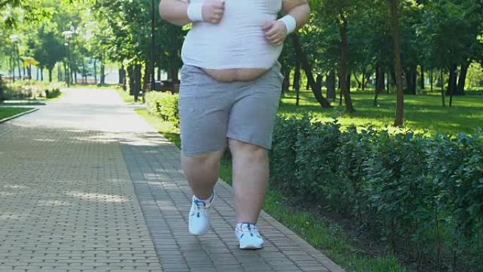 大肚子的胖子清晨在公园跑步，渴望减肥