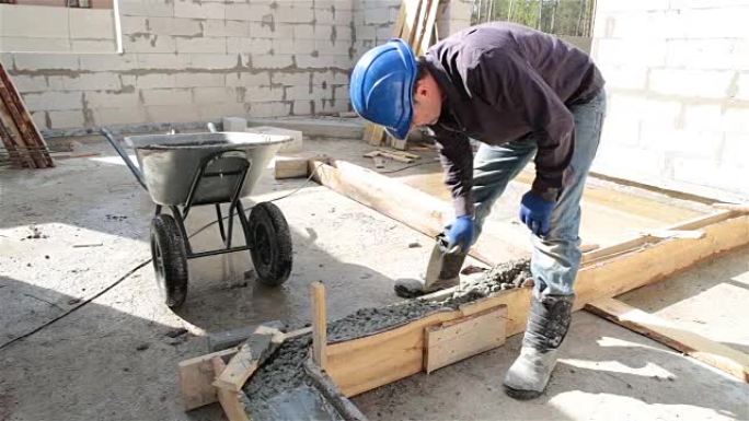 工人在砖石抹子的帮助下将混凝土放入模板中。